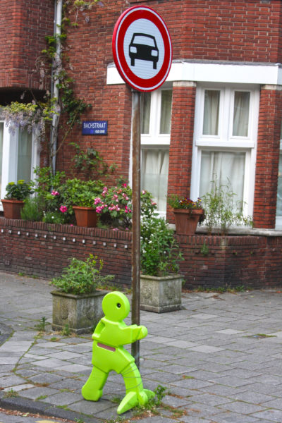 Plastic green man holding signpost